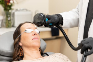 A close up of Enrichment Skin Solution's Lumecca IPL device as it slowly passes over a female client's forehead. Our version of laser skin resurfacing, intense pulsed light near Maple Grove reduces hyperpigmentation to even out the complexion.